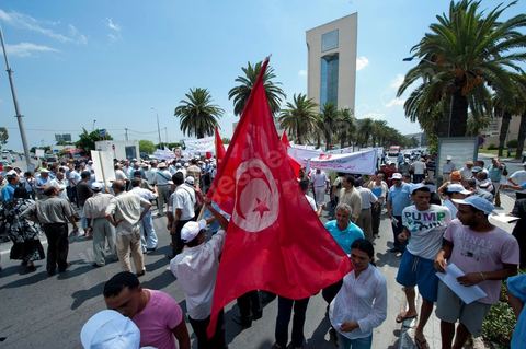 15 août 2011 : L'Union Générale Tunisienne du Travail a organisé une marche de protestation ''pour la réalisation des objectifs de la révolution et en mémoire des martyrs'' qui a débuté lundi 15 août 2011 à midi devant la bourse du travail à Tunis avant de parcourir l'avenue Mohamed V et de se disperser devant la place des droits de l'Homme.Ont participé à cette marche, les structures régionales et locales de base de l'Union, des partis politiques, des personnalités nationales, des composantes de la société civile, des intellectuels et des artistes.Les manifestants ont exprimé des revendications à caractère social et politique exigeant notamment le départ du Gouvernement de transition et de demander des comptes aux symboles de la corruption, notamment par une restitution des avoirs du peuple, spoliés par la famille du président déchu, la réforme de la Justice et l'emploi aux chômeurs.Les manifestants ont dénoncé la hausse des prix et appelé au respect des principes de la révolution et à la fidélité au sang des martyrs.La marche a été marquée par un arrêt symbolique devant le siège de l'ancien Rassemblement Constitutionnel Démocratique dissous."La Tunisie libre et les voleurs dehors", "Peuple, révolte-toi contre les restants de la dictature", "Pas de liberté, pas de retour, pour les bandes du destour" ont scandé les manifestants.