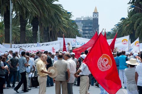 15 août 2011 : L'Union Générale Tunisienne du Travail a organisé une marche de protestation ''pour la réalisation des objectifs de la révolution et en mémoire des martyrs'' qui a débuté lundi 15 août 2011 à midi devant la bourse du travail à Tunis avant de parcourir l'avenue Mohamed V et de se disperser devant la place des droits de l'Homme.Ont participé à cette marche, les structures régionales et locales de base de l'Union, des partis politiques, des personnalités nationales, des composantes de la société civile, des intellectuels et des artistes.Les manifestants ont exprimé des revendications à caractère social et politique exigeant notamment le départ du Gouvernement de transition et de demander des comptes aux symboles de la corruption, notamment par une restitution des avoirs du peuple, spoliés par la famille du président déchu, la réforme de la Justice et l'emploi aux chômeurs.Les manifestants ont dénoncé la hausse des prix et appelé au respect des principes de la révolution et à la fidélité au sang des martyrs.La marche a été marquée par un arrêt symbolique devant le siège de l'ancien Rassemblement Constitutionnel Démocratique dissous."La Tunisie libre et les voleurs dehors", "Peuple, révolte-toi contre les restants de la dictature", "Pas de liberté, pas de retour, pour les bandes du destour" ont scandé les manifestants.