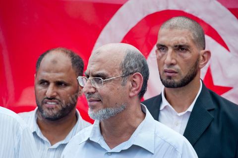 15 août 2011 : Hamadi JEBALI, n°2 du parti à tendance islamique Ennahda et ses gardes du corps à la manif de l'UGGT. L'Union Générale Tunisienne du Travail a organisé une marche de protestation ''pour la réalisation des objectifs de la révolution et en mémoire des martyrs'' qui a débuté lundi 15 août 2011 à midi devant la bourse du travail à Tunis avant de parcourir l'avenue Mohamed V et de se disperser devant la place des droits de l'Homme.Ont participé à cette marche, les structures régionales et locales de base de l'Union, des partis politiques, des personnalités nationales, des composantes de la société civile, des intellectuels et des artistes.Les manifestants ont exprimé des revendications à caractère social et politique exigeant notamment le départ du Gouvernement de transition et de demander des comptes aux symboles de la corruption, notamment par une restitution des avoirs du peuple, spoliés par la famille du président déchu, la réforme de la Justice et l'emploi aux chômeurs.Les manifestants ont dénoncé la hausse des prix et appelé au respect des principes de la révolution et à la fidélité au sang des martyrs.La marche a été marquée par un arrêt symbolique devant le siège de l'ancien Rassemblement Constitutionnel Démocratique dissous."La Tunisie libre et les voleurs dehors", "Peuple, révolte-toi contre les restants de la dictature", "Pas de liberté, pas de retour, pour les bandes du destour" ont scandé les manifestants.