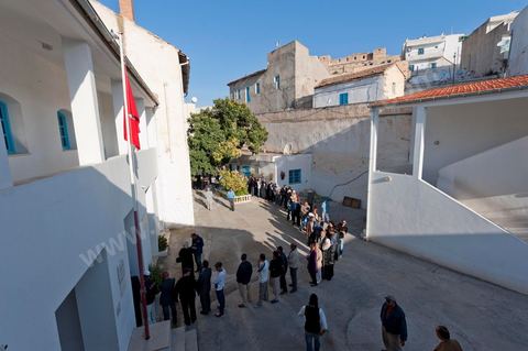 Dans la cour de l'école les gens viennent dès la première heure pour voter dans un bureau de vote au centre ville du Kef