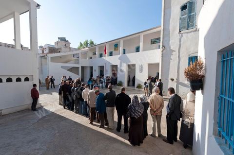 Dans la cour de l'école les gens viennent dès la première heure pour voter dans un bureau de vote au centre ville du Kef