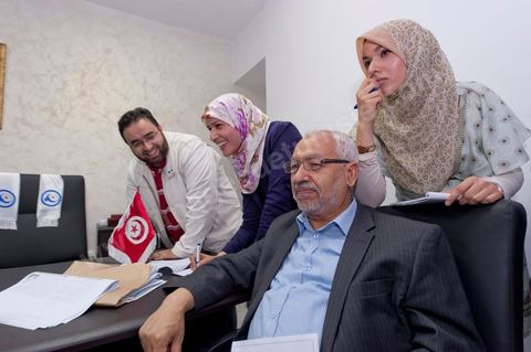 Dans le bureau Rached Ghannouchi, président et fondateur de Ennahdha, notent avec ses filles Intissar (à droite), Yosr (au centre) et Bara (à gauche) son fils les résultats provisoires  lors de la soirée de résultats au QG du parti Ennahda à Tunis. 