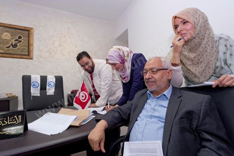 Dans le bureau Rached Ghannouchi, président et fondateur de Ennahdha, notent avec ses filles Intissar (à droite), Yosr (au centre) et Bara (à gauche) son fils les résultats provisoires  lors de la soirée de résultats au QG du parti Ennahda à Tunis. 