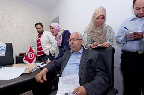 Dans le bureau Rached Ghannouchi, président et fondateur de Ennahdha, notent avec ses filles Intissar (à droite), Yosr (au centre) et Bara (à gauche) son fils les résultats provisoires  lors de la soirée de résultats au QG du parti Ennahda à Tunis. 