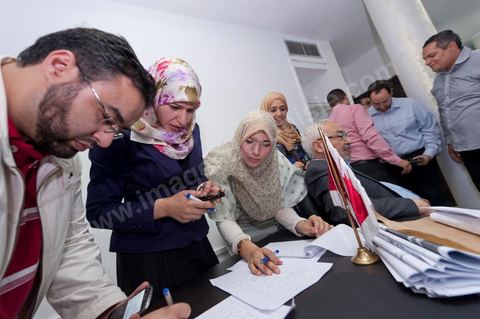 In the office of Rached Ghannouchi, president and founder of Ennahda, his daughters Intissar (right), Yosr (center), and Bara (left), while his son notes the  preliminary results during the election night event at Ennahda’s party headquarters in Tunis. 