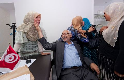In the office of Rached Ghannouchi, president and founder of Ennahda, he poses with his daughters Soumaya (center), Intissar (left), and Yosr (right) congratulate one another upon the announcement of the preliminary results during the election night event at the Ennahda party headquarters in Tunis. 