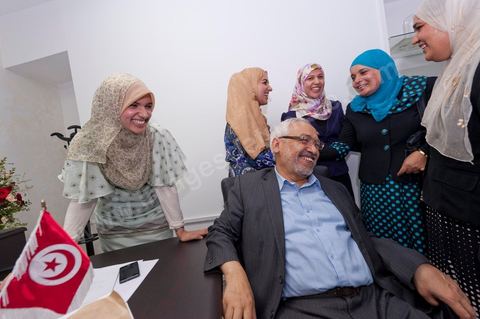 In the office of Rached Ghannouchi, president and founder of Ennahda, he poses with his daughters Soumaya (center), Intissar (left), and Yosr (right) congratulate one another upon the announcement of the preliminary results during the election night event at the Ennahda party headquarters in Tunis. 