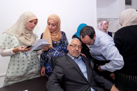In the office of Rached Ghannouchi, president and founder of Ennahda, he poses with his daughters Soumaya (center), Intissar (left), and Yosr (right) congratulate one another upon the announcement of the preliminary results during the election night event at the Ennahda party headquarters in Tunis. 