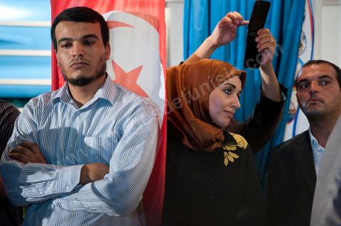 Soumaya Ghannouchi, Rached's daughter, watches the press conference in front of the Ennahda party headquarters; the crowd begins to gather as soon as the official announcement of the preliminary results declares Ennahda the winner.