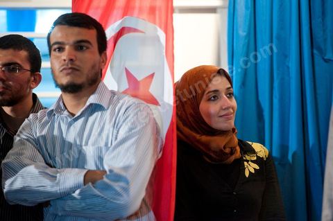 Soumaya Ghannouchi, Rached's daughter, watches the press conference in front of the Ennahda party headquarters; the crowd begins to gather as soon as the official announcement of the preliminary results declares Ennahda the winner.
