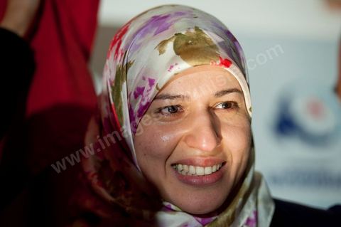 Ysor Ghannouchi, Rached's daughter, weeps with joy at the prospect of her father's party's success outside the Ennahdha party headquarters; a crowd gathers as soon as the official announcement of the initial results—which indicate a victory for Ennahdha—is made.