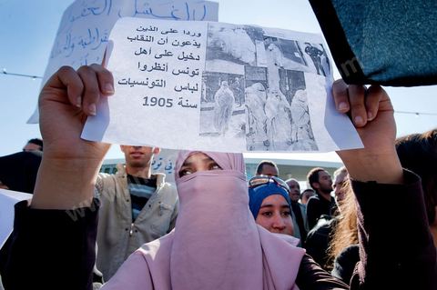 3 décembre 2011 : par sa pancarte cette jeune islamiste veut démontrer que le niqab fait partie d ela culture tunisienne, en 1905, au 3ème jour du sitin de Bardo 1. Un nouvel affrontement apparait d'un côté les sitinneurs qui protestent contre les tractations politiques internes de l’Assemblée Constituante et de l'autre côté plus de deux milles militants d'Ennahdha venus soutenir le nouveau pouvoir et encadrer une centaine de salafistes aggressifs. Les affrontemants de la journée furent uniquement verbaux grâce à l'impressionant service de sécurité d'Ennahda qui sut avec la police contenir les salfistes qui la nuit venue aggressèrent les sitinneurs protégés par la police.