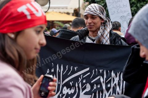 14 janvier 2012 : Un jeune garçonpose avec le drapeau du parti salafiste Hizbut Tharir sur l'aveneu Habib Bourguiba lors de la Commémoration à Tunis du premier anniversaire de la Révolution tunisienne, le 14 janvier étant la date de la fuite de l'ex Président vers l'Arabie Saoudide. 