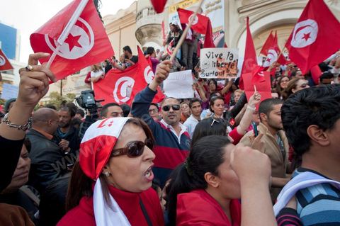 March 20, 2012: Nearly 6,000 Tunisians gathered Tuesday on Bourguiba Avenue in Tunis to celebrate Independence Day and “defend democracy” against “reactionary” forces, amid tensions fueled by the debate over identity and the role of religion.Tunisian flags were everywhere, horns blared, and the national anthem rang out: the demonstrators, who had come in response to calls on social media and from civic movements, chanted, “The people want a secular state!” “No to reactionary thinking, no to the caliphate,” or “We will not let obscurantist forces steal our revolution.”
The slogans of the revolution—“work, freedom, dignity”—were also chanted in unison. “In the name of the worker and the farmer, we continue to fight,” proclaimed one banner, while another demanded “jobs, or the government’s resignation.”  The 56th anniversary of independence—achieved on March 20, 1956, after 75 years of French protectorate rule—is taking place against a delicate backdrop, marked by growing tensions between the “Islamist” camp—which won the elections—and the “modernist” camp. The debate, exacerbated by incidents linked to Salafist radicals, centers on the question of Tunisian identity and the role religion should play in the country’s future constitution.