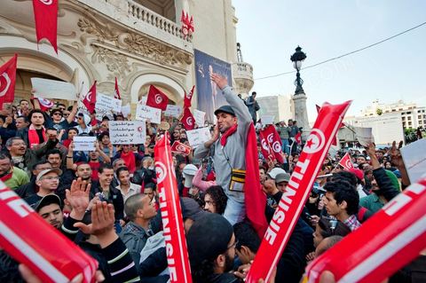 March 20, 2012: Nearly 6,000 Tunisians gathered Tuesday on Bourguiba Avenue in Tunis to celebrate Independence Day and “defend democracy” against “reactionary” forces, amid tensions fueled by the debate over identity and the role of religion.Tunisian flags were everywhere, horns blared, and the national anthem rang out: the demonstrators, who had come in response to calls on social media and from civic movements, chanted, “The people want a secular state!” “No to reactionary thinking, no to the caliphate,” or “We will not let obscurantist forces steal our revolution.”
The slogans of the revolution—“work, freedom, dignity”—were also chanted in unison. “In the name of the worker and the farmer, we continue to fight,” proclaimed one banner, while another demanded “jobs, or the government’s resignation.”  The 56th anniversary of independence—achieved on March 20, 1956, after 75 years of French protectorate rule—is taking place against a delicate backdrop, marked by growing tensions between the “Islamist” camp—which won the elections—and the “modernist” camp. The debate, exacerbated by incidents linked to Salafist radicals, centers on the question of Tunisian identity and the role religion should play in the country’s future constitution.
