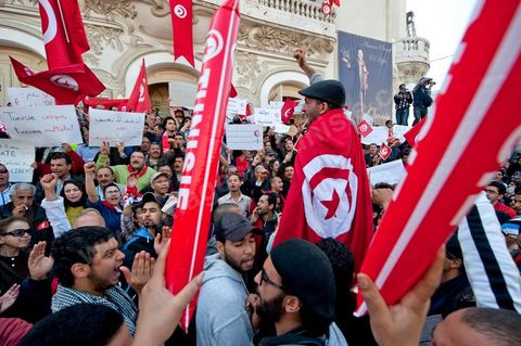 March 20, 2012: Nearly 6,000 Tunisians gathered Tuesday on Bourguiba Avenue in Tunis to celebrate Independence Day and “defend democracy” against “reactionary” forces, amid tensions fueled by the debate over identity and the role of religion.Tunisian flags were everywhere, horns blared, and the national anthem rang out: the demonstrators, who had come in response to calls on social media and from civic movements, chanted, “The people want a secular state!” “No to reactionary thinking, no to the caliphate,” or “We will not let obscurantist forces steal our revolution.”
The slogans of the revolution—“work, freedom, dignity”—were also chanted in unison. “In the name of the worker and the farmer, we continue to fight,” proclaimed one banner, while another demanded “jobs, or the government’s resignation.”  The 56th anniversary of independence—achieved on March 20, 1956, after 75 years of French protectorate rule—is taking place against a delicate backdrop, marked by growing tensions between the “Islamist” camp—which won the elections—and the “modernist” camp. The debate, exacerbated by incidents linked to Salafist radicals, centers on the question of Tunisian identity and the role religion should play in the country’s future constitution.