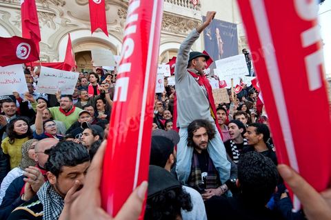 March 20, 2012: Nearly 6,000 Tunisians gathered Tuesday on Bourguiba Avenue in Tunis to celebrate Independence Day and “defend democracy” against “reactionary” forces, amid tensions fueled by the debate over identity and the role of religion.Tunisian flags were everywhere, horns blared, and the national anthem rang out: the demonstrators, who had come in response to calls on social media and from civic movements, chanted, “The people want a secular state!” “No to reactionary thinking, no to the caliphate,” or “We will not let obscurantist forces steal our revolution.”
The slogans of the revolution—“work, freedom, dignity”—were also chanted in unison. “In the name of the worker and the farmer, we continue to fight,” proclaimed one banner, while another demanded “jobs, or the government’s resignation.”  The 56th anniversary of independence—achieved on March 20, 1956, after 75 years of French protectorate rule—is taking place against a delicate backdrop, marked by growing tensions between the “Islamist” camp—which won the elections—and the “modernist” camp. The debate, exacerbated by incidents linked to Salafist radicals, centers on the question of Tunisian identity and the role religion should play in the country’s future constitution.