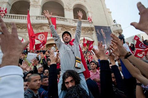 March 20, 2012: Nearly 6,000 Tunisians gathered Tuesday on Bourguiba Avenue in Tunis to celebrate Independence Day and “defend democracy” against “reactionary” forces, amid tensions fueled by the debate over identity and the role of religion.Tunisian flags were everywhere, horns blared, and the national anthem rang out: the demonstrators, who had come in response to calls on social media and from civic movements, chanted, “The people want a secular state!” “No to reactionary thinking, no to the caliphate,” or “We will not let obscurantist forces steal our revolution.”
The slogans of the revolution—“work, freedom, dignity”—were also chanted in unison. “In the name of the worker and the farmer, we continue to fight,” proclaimed one banner, while another demanded “jobs, or the government’s resignation.”  The 56th anniversary of independence—achieved on March 20, 1956, after 75 years of French protectorate rule—is taking place against a delicate backdrop, marked by growing tensions between the “Islamist” camp—which won the elections—and the “modernist” camp. The debate, exacerbated by incidents linked to Salafist radicals, centers on the question of Tunisian identity and the role religion should play in the country’s future constitution.