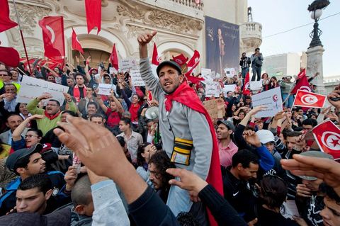 March 20, 2012: Nearly 6,000 Tunisians gathered Tuesday on Bourguiba Avenue in Tunis to celebrate Independence Day and “defend democracy” against “reactionary” forces, amid tensions fueled by the debate over identity and the role of religion.Tunisian flags were everywhere, horns blared, and the national anthem rang out: the demonstrators, who had come in response to calls on social media and from civic movements, chanted, “The people want a secular state!” “No to reactionary thinking, no to the caliphate,” or “We will not let obscurantist forces steal our revolution.”
The slogans of the revolution—“work, freedom, dignity”—were also chanted in unison. “In the name of the worker and the farmer, we continue to fight,” proclaimed one banner, while another demanded “jobs, or the government’s resignation.”  The 56th anniversary of independence—achieved on March 20, 1956, after 75 years of French protectorate rule—is taking place against a delicate backdrop, marked by growing tensions between the “Islamist” camp—which won the elections—and the “modernist” camp. The debate, exacerbated by incidents linked to Salafist radicals, centers on the question of Tunisian identity and the role religion should play in the country’s future constitution.