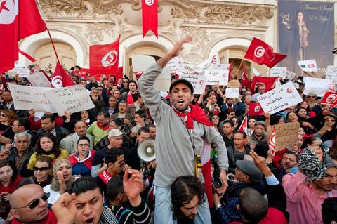 March 20, 2012: Nearly 6,000 Tunisians gathered Tuesday on Bourguiba Avenue in Tunis to celebrate Independence Day and “defend democracy” against “reactionary” forces, amid tensions fueled by the debate over identity and the role of religion.Tunisian flags were everywhere, horns blared, and the national anthem rang out: the demonstrators, who had come in response to calls on social media and from civic movements, chanted, “The people want a secular state!” “No to reactionary thinking, no to the caliphate,” or “We will not let obscurantist forces steal our revolution.”
The slogans of the revolution—“work, freedom, dignity”—were also chanted in unison. “In the name of the worker and the farmer, we continue to fight,” proclaimed one banner, while another demanded “jobs, or the government’s resignation.”  The 56th anniversary of independence—achieved on March 20, 1956, after 75 years of French protectorate rule—is taking place against a delicate backdrop, marked by growing tensions between the “Islamist” camp—which won the elections—and the “modernist” camp. The debate, exacerbated by incidents linked to Salafist radicals, centers on the question of Tunisian identity and the role religion should play in the country’s future constitution.