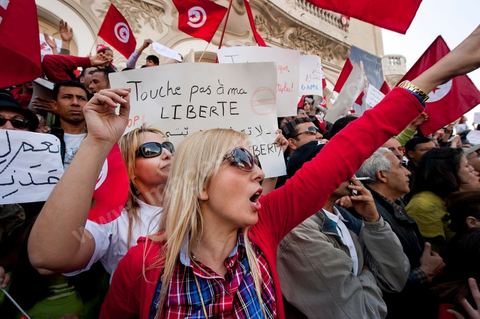 March 20, 2012: Nearly 6,000 Tunisians gathered Tuesday on Bourguiba Avenue in Tunis to celebrate Independence Day and “defend democracy” against “reactionary” forces, amid tensions fueled by the debate over identity and the role of religion.Tunisian flags were everywhere, horns blared, and the national anthem rang out: the demonstrators, who had come in response to calls on social media and from civic movements, chanted, “The people want a secular state!” “No to reactionary thinking, no to the caliphate,” or “We will not let obscurantist forces steal our revolution.”
The slogans of the revolution—“work, freedom, dignity”—were also chanted in unison. “In the name of the worker and the farmer, we continue to fight,” proclaimed one banner, while another demanded “jobs, or the government’s resignation.”  The 56th anniversary of independence—achieved on March 20, 1956, after 75 years of French protectorate rule—is taking place against a delicate backdrop, marked by growing tensions between the “Islamist” camp—which won the elections—and the “modernist” camp. The debate, exacerbated by incidents linked to Salafist radicals, centers on the question of Tunisian identity and the role religion should play in the country’s future constitution.
