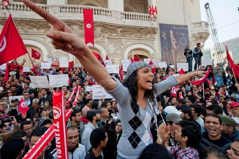 March 20, 2012: Nearly 6,000 Tunisians gathered Tuesday on Bourguiba Avenue in Tunis to celebrate Independence Day and “defend democracy” against “reactionary” forces, amid tensions fueled by the debate over identity and the role of religion.Tunisian flags were everywhere, horns blared, and the national anthem rang out: the demonstrators, who had come in response to calls on social media and from civic movements, chanted, “The people want a secular state!” “No to reactionary thinking, no to the caliphate,” or “We will not let obscurantist forces steal our revolution.”
The slogans of the revolution—“work, freedom, dignity”—were also chanted in unison. “In the name of the worker and the farmer, we continue to fight,” proclaimed one banner, while another demanded “jobs, or the government’s resignation.”  The 56th anniversary of independence—achieved on March 20, 1956, after 75 years of French protectorate rule—is taking place against a delicate backdrop, marked by growing tensions between the “Islamist” camp—which won the elections—and the “modernist” camp. The debate, exacerbated by incidents linked to Salafist radicals, centers on the question of Tunisian identity and the role religion should play in the country’s future constitution.