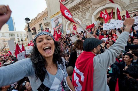 March 20, 2012: Nearly 6,000 Tunisians gathered Tuesday on Bourguiba Avenue in Tunis to celebrate Independence Day and “defend democracy” against “reactionary” forces, amid tensions fueled by the debate over identity and the role of religion.Tunisian flags were everywhere, horns blared, and the national anthem rang out: the demonstrators, who had come in response to calls on social media and from civic movements, chanted, “The people want a secular state!” “No to reactionary thinking, no to the caliphate,” or “We will not let obscurantist forces steal our revolution.”
The slogans of the revolution—“work, freedom, dignity”—were also chanted in unison. “In the name of the worker and the farmer, we continue to fight,” proclaimed one banner, while another demanded “jobs, or the government’s resignation.”  The 56th anniversary of independence—achieved on March 20, 1956, after 75 years of French protectorate rule—is taking place against a delicate backdrop, marked by growing tensions between the “Islamist” camp—which won the elections—and the “modernist” camp. The debate, exacerbated by incidents linked to Salafist radicals, centers on the question of Tunisian identity and the role religion should play in the country’s future constitution.