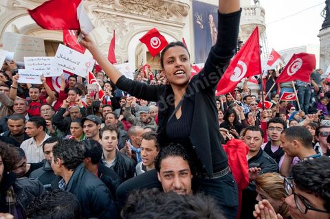 March 20, 2012: Nearly 6,000 Tunisians gathered Tuesday on Bourguiba Avenue in Tunis to celebrate Independence Day and “defend democracy” against “reactionary” forces, amid tensions fueled by the debate over identity and the role of religion.Tunisian flags were everywhere, horns blared, and the national anthem rang out: the demonstrators, who had come in response to calls on social media and from civic movements, chanted, “The people want a secular state!” “No to reactionary thinking, no to the caliphate,” or “We will not let obscurantist forces steal our revolution.”
The slogans of the revolution—“work, freedom, dignity”—were also chanted in unison. “In the name of the worker and the farmer, we continue to fight,” proclaimed one banner, while another demanded “jobs, or the government’s resignation.”  The 56th anniversary of independence—achieved on March 20, 1956, after 75 years of French protectorate rule—is taking place against a delicate backdrop, marked by growing tensions between the “Islamist” camp—which won the elections—and the “modernist” camp. The debate, exacerbated by incidents linked to Salafist radicals, centers on the question of Tunisian identity and the role religion should play in the country’s future constitution.