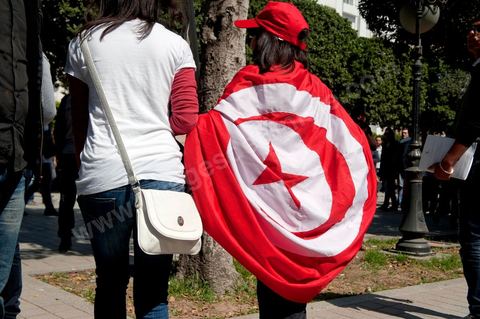 March 20, 2012: Nearly 6,000 Tunisians gathered Tuesday on Bourguiba Avenue in Tunis to celebrate Independence Day and “defend democracy” against “reactionary” forces, amid tensions fueled by the debate over identity and the role of religion.Tunisian flags were everywhere, horns blared, and the national anthem rang out: the demonstrators, who had come in response to calls on social media and from civic movements, chanted, “The people want a secular state!” “No to reactionary thinking, no to the caliphate,” or “We will not let obscurantist forces steal our revolution.”
The slogans of the revolution—“work, freedom, dignity”—were also chanted in unison. “In the name of the worker and the farmer, we continue to fight,” proclaimed one banner, while another demanded “jobs, or the government’s resignation.”  The 56th anniversary of independence—achieved on March 20, 1956, after 75 years of French protectorate rule—is taking place against a delicate backdrop, marked by growing tensions between the “Islamist” camp—which won the elections—and the “modernist” camp. The debate, exacerbated by incidents linked to Salafist radicals, centers on the question of Tunisian identity and the role religion should play in the country’s future constitution.