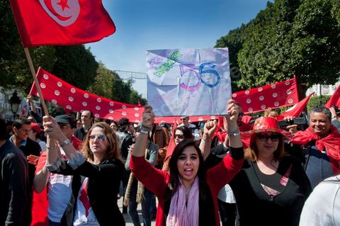 March 20, 2012: Nearly 6,000 Tunisians gathered Tuesday on Bourguiba Avenue in Tunis to celebrate Independence Day and “defend democracy” against “reactionary” forces, amid tensions fueled by the debate over identity and the role of religion.Tunisian flags were everywhere, horns blared, and the national anthem rang out: the demonstrators, who had come in response to calls on social media and from civic movements, chanted, “The people want a secular state!” “No to reactionary thinking, no to the caliphate,” or “We will not let obscurantist forces steal our revolution.”
The slogans of the revolution—“work, freedom, dignity”—were also chanted in unison. “In the name of the worker and the farmer, we continue to fight,” proclaimed one banner, while another demanded “jobs, or the government’s resignation.”  The 56th anniversary of independence—achieved on March 20, 1956, after 75 years of French protectorate rule—is taking place against a delicate backdrop, marked by growing tensions between the “Islamist” camp—which won the elections—and the “modernist” camp. The debate, exacerbated by incidents linked to Salafist radicals, centers on the question of Tunisian identity and the role religion should play in the country’s future constitution.