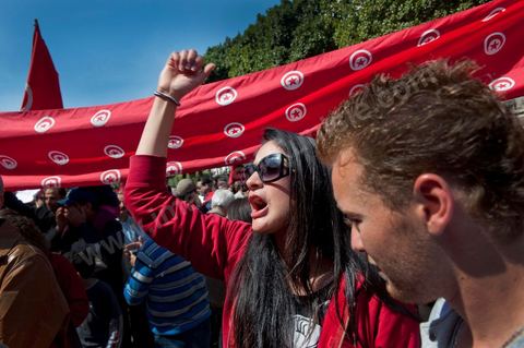 March 20, 2012: Nearly 6,000 Tunisians gathered Tuesday on Bourguiba Avenue in Tunis to celebrate Independence Day and “defend democracy” against “reactionary” forces, amid tensions fueled by the debate over identity and the role of religion.Tunisian flags were everywhere, horns blared, and the national anthem rang out: the demonstrators, who had come in response to calls on social media and from civic movements, chanted, “The people want a secular state!” “No to reactionary thinking, no to the caliphate,” or “We will not let obscurantist forces steal our revolution.”
The slogans of the revolution—“work, freedom, dignity”—were also chanted in unison. “In the name of the worker and the farmer, we continue to fight,” proclaimed one banner, while another demanded “jobs, or the government’s resignation.”  The 56th anniversary of independence—achieved on March 20, 1956, after 75 years of French protectorate rule—is taking place against a delicate backdrop, marked by growing tensions between the “Islamist” camp—which won the elections—and the “modernist” camp. The debate, exacerbated by incidents linked to Salafist radicals, centers on the question of Tunisian identity and the role religion should play in the country’s future constitution.