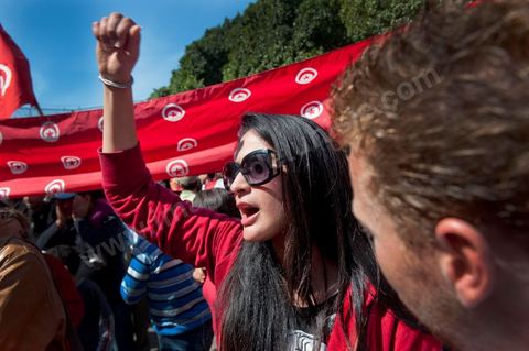 March 20, 2012: Nearly 6,000 Tunisians gathered Tuesday on Bourguiba Avenue in Tunis to celebrate Independence Day and “defend democracy” against “reactionary” forces, amid tensions fueled by the debate over identity and the role of religion.Tunisian flags were everywhere, horns blared, and the national anthem rang out: the demonstrators, who had come in response to calls on social media and from civic movements, chanted, “The people want a secular state!” “No to reactionary thinking, no to the caliphate,” or “We will not let obscurantist forces steal our revolution.”
The slogans of the revolution—“work, freedom, dignity”—were also chanted in unison. “In the name of the worker and the farmer, we continue to fight,” proclaimed one banner, while another demanded “jobs, or the government’s resignation.”  The 56th anniversary of independence—achieved on March 20, 1956, after 75 years of French protectorate rule—is taking place against a delicate backdrop, marked by growing tensions between the “Islamist” camp—which won the elections—and the “modernist” camp. The debate, exacerbated by incidents linked to Salafist radicals, centers on the question of Tunisian identity and the role religion should play in the country’s future constitution.