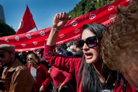 March 20, 2012: Nearly 6,000 Tunisians gathered Tuesday on Bourguiba Avenue in Tunis to celebrate Independence Day and “defend democracy” against “reactionary” forces, amid tensions fueled by the debate over identity and the role of religion.Tunisian flags were everywhere, horns blared, and the national anthem rang out: the demonstrators, who had come in response to calls on social media and from civic movements, chanted, “The people want a secular state!” “No to reactionary thinking, no to the caliphate,” or “We will not let obscurantist forces steal our revolution.”
The slogans of the revolution—“work, freedom, dignity”—were also chanted in unison. “In the name of the worker and the farmer, we continue to fight,” proclaimed one banner, while another demanded “jobs, or the government’s resignation.”  The 56th anniversary of independence—achieved on March 20, 1956, after 75 years of French protectorate rule—is taking place against a delicate backdrop, marked by growing tensions between the “Islamist” camp—which won the elections—and the “modernist” camp. The debate, exacerbated by incidents linked to Salafist radicals, centers on the question of Tunisian identity and the role religion should play in the country’s future constitution.