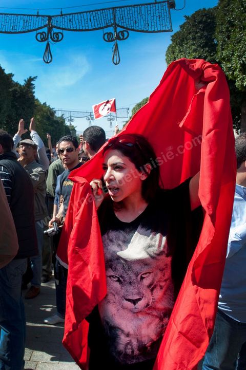 March 20, 2012: Nearly 6,000 Tunisians gathered Tuesday on Bourguiba Avenue in Tunis to celebrate Independence Day and “defend democracy” against “reactionary” forces, amid tensions fueled by the debate over identity and the role of religion.Tunisian flags were everywhere, horns blared, and the national anthem rang out: the demonstrators, who had come in response to calls on social media and from civic movements, chanted, “The people want a secular state!” “No to reactionary thinking, no to the caliphate,” or “We will not let obscurantist forces steal our revolution.”
The slogans of the revolution—“work, freedom, dignity”—were also chanted in unison. “In the name of the worker and the farmer, we continue to fight,” proclaimed one banner, while another demanded “jobs, or the government’s resignation.”  The 56th anniversary of independence—achieved on March 20, 1956, after 75 years of French protectorate rule—is taking place against a delicate backdrop, marked by growing tensions between the “Islamist” camp—which won the elections—and the “modernist” camp. The debate, exacerbated by incidents linked to Salafist radicals, centers on the question of Tunisian identity and the role religion should play in the country’s future constitution.