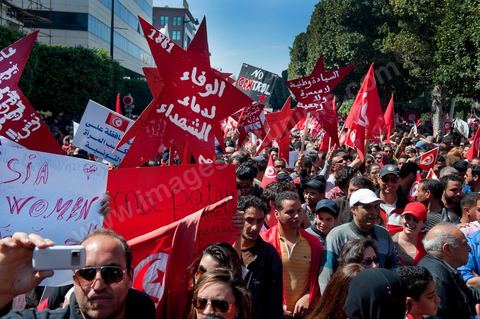 March 20, 2012: Nearly 6,000 Tunisians gathered Tuesday on Bourguiba Avenue in Tunis to celebrate Independence Day and “defend democracy” against “reactionary” forces, amid tensions fueled by the debate over identity and the role of religion.Tunisian flags were everywhere, horns blared, and the national anthem rang out: the demonstrators, who had come in response to calls on social media and from civic movements, chanted, “The people want a secular state!” “No to reactionary thinking, no to the caliphate,” or “We will not let obscurantist forces steal our revolution.”
The slogans of the revolution—“work, freedom, dignity”—were also chanted in unison. “In the name of the worker and the farmer, we continue to fight,” proclaimed one banner, while another demanded “jobs, or the government’s resignation.”  The 56th anniversary of independence—achieved on March 20, 1956, after 75 years of French protectorate rule—is taking place against a delicate backdrop, marked by growing tensions between the “Islamist” camp—which won the elections—and the “modernist” camp. The debate, exacerbated by incidents linked to Salafist radicals, centers on the question of Tunisian identity and the role religion should play in the country’s future constitution.