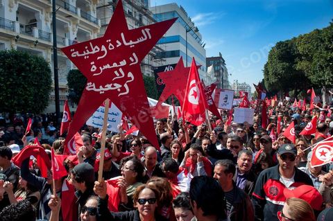 March 20, 2012: Nearly 6,000 Tunisians gathered Tuesday on Bourguiba Avenue in Tunis to celebrate Independence Day and “defend democracy” against “reactionary” forces, amid tensions fueled by the debate over identity and the role of religion.Tunisian flags were everywhere, horns blared, and the national anthem rang out: the demonstrators, who had come in response to calls on social media and from civic movements, chanted, “The people want a secular state!” “No to reactionary thinking, no to the caliphate,” or “We will not let obscurantist forces steal our revolution.”
The slogans of the revolution—“work, freedom, dignity”—were also chanted in unison. “In the name of the worker and the farmer, we continue to fight,” proclaimed one banner, while another demanded “jobs, or the government’s resignation.”  The 56th anniversary of independence—achieved on March 20, 1956, after 75 years of French protectorate rule—is taking place against a delicate backdrop, marked by growing tensions between the “Islamist” camp—which won the elections—and the “modernist” camp. The debate, exacerbated by incidents linked to Salafist radicals, centers on the question of Tunisian identity and the role religion should play in the country’s future constitution.