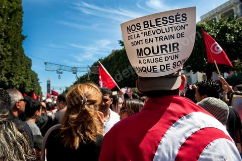 March 20, 2012: Nearly 6,000 Tunisians gathered Tuesday on Bourguiba Avenue in Tunis to celebrate Independence Day and “defend democracy” against “reactionary” forces, amid tensions fueled by the debate over identity and the role of religion.Tunisian flags were everywhere, horns blared, and the national anthem rang out: the demonstrators, who had come in response to calls on social media and from civic movements, chanted, “The people want a secular state!” “No to reactionary thinking, no to the caliphate,” or “We will not let obscurantist forces steal our revolution.”
The slogans of the revolution—“work, freedom, dignity”—were also chanted in unison. “In the name of the worker and the farmer, we continue to fight,” proclaimed one banner, while another demanded “jobs, or the government’s resignation.”  The 56th anniversary of independence—achieved on March 20, 1956, after 75 years of French protectorate rule—is taking place against a delicate backdrop, marked by growing tensions between the “Islamist” camp—which won the elections—and the “modernist” camp. The debate, exacerbated by incidents linked to Salafist radicals, centers on the question of Tunisian identity and the role religion should play in the country’s future constitution.