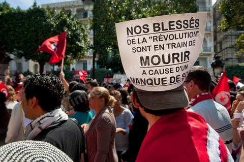 March 20, 2012: Nearly 6,000 Tunisians gathered Tuesday on Bourguiba Avenue in Tunis to celebrate Independence Day and “defend democracy” against “reactionary” forces, amid tensions fueled by the debate over identity and the role of religion.Tunisian flags were everywhere, horns blared, and the national anthem rang out: the demonstrators, who had come in response to calls on social media and from civic movements, chanted, “The people want a secular state!” “No to reactionary thinking, no to the caliphate,” or “We will not let obscurantist forces steal our revolution.”
The slogans of the revolution—“work, freedom, dignity”—were also chanted in unison. “In the name of the worker and the farmer, we continue to fight,” proclaimed one banner, while another demanded “jobs, or the government’s resignation.”  The 56th anniversary of independence—achieved on March 20, 1956, after 75 years of French protectorate rule—is taking place against a delicate backdrop, marked by growing tensions between the “Islamist” camp—which won the elections—and the “modernist” camp. The debate, exacerbated by incidents linked to Salafist radicals, centers on the question of Tunisian identity and the role religion should play in the country’s future constitution.