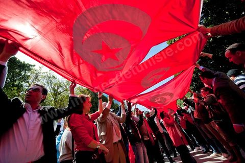 March 20, 2012: Nearly 6,000 Tunisians gathered Tuesday on Bourguiba Avenue in Tunis to celebrate Independence Day and “defend democracy” against “reactionary” forces, amid tensions fueled by the debate over identity and the role of religion.Tunisian flags were everywhere, horns blared, and the national anthem rang out: the demonstrators, who had come in response to calls on social media and from civic movements, chanted, “The people want a secular state!” “No to reactionary thinking, no to the caliphate,” or “We will not let obscurantist forces steal our revolution.”
The slogans of the revolution—“work, freedom, dignity”—were also chanted in unison. “In the name of the worker and the farmer, we continue to fight,” proclaimed one banner, while another demanded “jobs, or the government’s resignation.”  The 56th anniversary of independence—achieved on March 20, 1956, after 75 years of French protectorate rule—is taking place against a delicate backdrop, marked by growing tensions between the “Islamist” camp—which won the elections—and the “modernist” camp. The debate, exacerbated by incidents linked to Salafist radicals, centers on the question of Tunisian identity and the role religion should play in the country’s future constitution.