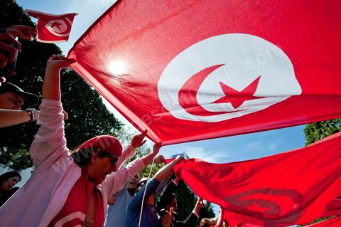 March 20, 2012: Nearly 6,000 Tunisians gathered Tuesday on Bourguiba Avenue in Tunis to celebrate Independence Day and “defend democracy” against “reactionary” forces, amid tensions fueled by the debate over identity and the role of religion.Tunisian flags were everywhere, horns blared, and the national anthem rang out: the demonstrators, who had come in response to calls on social media and from civic movements, chanted, “The people want a secular state!” “No to reactionary thinking, no to the caliphate,” or “We will not let obscurantist forces steal our revolution.”
The slogans of the revolution—“work, freedom, dignity”—were also chanted in unison. “In the name of the worker and the farmer, we continue to fight,” proclaimed one banner, while another demanded “jobs, or the government’s resignation.”  The 56th anniversary of independence—achieved on March 20, 1956, after 75 years of French protectorate rule—is taking place against a delicate backdrop, marked by growing tensions between the “Islamist” camp—which won the elections—and the “modernist” camp. The debate, exacerbated by incidents linked to Salafist radicals, centers on the question of Tunisian identity and the role religion should play in the country’s future constitution.