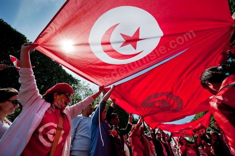 March 20, 2012: Nearly 6,000 Tunisians gathered Tuesday on Bourguiba Avenue in Tunis to celebrate Independence Day and “defend democracy” against “reactionary” forces, amid tensions fueled by the debate over identity and the role of religion.Tunisian flags were everywhere, horns blared, and the national anthem rang out: the demonstrators, who had come in response to calls on social media and from civic movements, chanted, “The people want a secular state!” “No to reactionary thinking, no to the caliphate,” or “We will not let obscurantist forces steal our revolution.”
The slogans of the revolution—“work, freedom, dignity”—were also chanted in unison. “In the name of the worker and the farmer, we continue to fight,” proclaimed one banner, while another demanded “jobs, or the government’s resignation.”  The 56th anniversary of independence—achieved on March 20, 1956, after 75 years of French protectorate rule—is taking place against a delicate backdrop, marked by growing tensions between the “Islamist” camp—which won the elections—and the “modernist” camp. The debate, exacerbated by incidents linked to Salafist radicals, centers on the question of Tunisian identity and the role religion should play in the country’s future constitution.