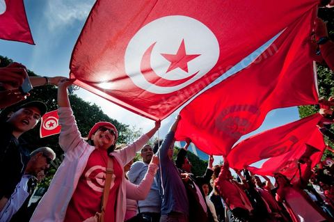 March 20, 2012: Nearly 6,000 Tunisians gathered Tuesday on Bourguiba Avenue in Tunis to celebrate Independence Day and “defend democracy” against “reactionary” forces, amid tensions fueled by the debate over identity and the role of religion.Tunisian flags were everywhere, horns blared, and the national anthem rang out: the demonstrators, who had come in response to calls on social media and from civic movements, chanted, “The people want a secular state!” “No to reactionary thinking, no to the caliphate,” or “We will not let obscurantist forces steal our revolution.”
The slogans of the revolution—“work, freedom, dignity”—were also chanted in unison. “In the name of the worker and the farmer, we continue to fight,” proclaimed one banner, while another demanded “jobs, or the government’s resignation.”  The 56th anniversary of independence—achieved on March 20, 1956, after 75 years of French protectorate rule—is taking place against a delicate backdrop, marked by growing tensions between the “Islamist” camp—which won the elections—and the “modernist” camp. The debate, exacerbated by incidents linked to Salafist radicals, centers on the question of Tunisian identity and the role religion should play in the country’s future constitution.