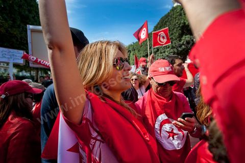 March 20, 2012: Nearly 6,000 Tunisians gathered Tuesday on Bourguiba Avenue in Tunis to celebrate Independence Day and “defend democracy” against “reactionary” forces, amid tensions fueled by the debate over identity and the role of religion.Tunisian flags were everywhere, horns blared, and the national anthem rang out: the demonstrators, who had come in response to calls on social media and from civic movements, chanted, “The people want a secular state!” “No to reactionary thinking, no to the caliphate,” or “We will not let obscurantist forces steal our revolution.”
The slogans of the revolution—“work, freedom, dignity”—were also chanted in unison. “In the name of the worker and the farmer, we continue to fight,” proclaimed one banner, while another demanded “jobs, or the government’s resignation.”  The 56th anniversary of independence—achieved on March 20, 1956, after 75 years of French protectorate rule—is taking place against a delicate backdrop, marked by growing tensions between the “Islamist” camp—which won the elections—and the “modernist” camp. The debate, exacerbated by incidents linked to Salafist radicals, centers on the question of Tunisian identity and the role religion should play in the country’s future constitution.