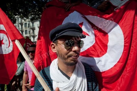 March 20, 2012: Nearly 6,000 Tunisians gathered Tuesday on Bourguiba Avenue in Tunis to celebrate Independence Day and “defend democracy” against “reactionary” forces, amid tensions fueled by the debate over identity and the role of religion.Tunisian flags were everywhere, horns blared, and the national anthem rang out: the demonstrators, who had come in response to calls on social media and from civic movements, chanted, “The people want a secular state!” “No to reactionary thinking, no to the caliphate,” or “We will not let obscurantist forces steal our revolution.”
The slogans of the revolution—“work, freedom, dignity”—were also chanted in unison. “In the name of the worker and the farmer, we continue to fight,” proclaimed one banner, while another demanded “jobs, or the government’s resignation.”  The 56th anniversary of independence—achieved on March 20, 1956, after 75 years of French protectorate rule—is taking place against a delicate backdrop, marked by growing tensions between the “Islamist” camp—which won the elections—and the “modernist” camp. The debate, exacerbated by incidents linked to Salafist radicals, centers on the question of Tunisian identity and the role religion should play in the country’s future constitution.