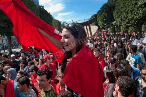 March 20, 2012: Nearly 6,000 Tunisians gathered Tuesday on Bourguiba Avenue in Tunis to celebrate Independence Day and “defend democracy” against “reactionary” forces, amid tensions fueled by the debate over identity and the role of religion.Tunisian flags were everywhere, horns blared, and the national anthem rang out: the demonstrators, who had come in response to calls on social media and from civic movements, chanted, “The people want a secular state!” “No to reactionary thinking, no to the caliphate,” or “We will not let obscurantist forces steal our revolution.”
The slogans of the revolution—“work, freedom, dignity”—were also chanted in unison. “In the name of the worker and the farmer, we continue to fight,” proclaimed one banner, while another demanded “jobs, or the government’s resignation.”  The 56th anniversary of independence—achieved on March 20, 1956, after 75 years of French protectorate rule—is taking place against a delicate backdrop, marked by growing tensions between the “Islamist” camp—which won the elections—and the “modernist” camp. The debate, exacerbated by incidents linked to Salafist radicals, centers on the question of Tunisian identity and the role religion should play in the country’s future constitution.
