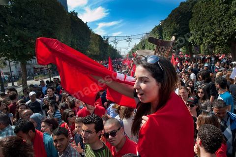 March 20, 2012: Nearly 6,000 Tunisians gathered Tuesday on Bourguiba Avenue in Tunis to celebrate Independence Day and “defend democracy” against “reactionary” forces, amid tensions fueled by the debate over identity and the role of religion.Tunisian flags were everywhere, horns blared, and the national anthem rang out: the demonstrators, who had come in response to calls on social media and from civic movements, chanted, “The people want a secular state!” “No to reactionary thinking, no to the caliphate,” or “We will not let obscurantist forces steal our revolution.”
The slogans of the revolution—“work, freedom, dignity”—were also chanted in unison. “In the name of the worker and the farmer, we continue to fight,” proclaimed one banner, while another demanded “jobs, or the government’s resignation.”  The 56th anniversary of independence—achieved on March 20, 1956, after 75 years of French protectorate rule—is taking place against a delicate backdrop, marked by growing tensions between the “Islamist” camp—which won the elections—and the “modernist” camp. The debate, exacerbated by incidents linked to Salafist radicals, centers on the question of Tunisian identity and the role religion should play in the country’s future constitution.