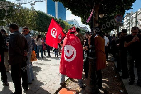 March 20, 2012: Nearly 6,000 Tunisians gathered Tuesday on Bourguiba Avenue in Tunis to celebrate Independence Day and “defend democracy” against “reactionary” forces, amid tensions fueled by the debate over identity and the role of religion.Tunisian flags were everywhere, horns blared, and the national anthem rang out: the demonstrators, who had come in response to calls on social media and from civic movements, chanted, “The people want a secular state!” “No to reactionary thinking, no to the caliphate,” or “We will not let obscurantist forces steal our revolution.”
The slogans of the revolution—“work, freedom, dignity”—were also chanted in unison. “In the name of the worker and the farmer, we continue to fight,” proclaimed one banner, while another demanded “jobs, or the government’s resignation.”  The 56th anniversary of independence—achieved on March 20, 1956, after 75 years of French protectorate rule—is taking place against a delicate backdrop, marked by growing tensions between the “Islamist” camp—which won the elections—and the “modernist” camp. The debate, exacerbated by incidents linked to Salafist radicals, centers on the question of Tunisian identity and the role religion should play in the country’s future constitution.