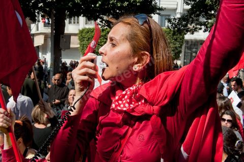 March 20, 2012: Nearly 6,000 Tunisians gathered Tuesday on Bourguiba Avenue in Tunis to celebrate Independence Day and “defend democracy” against “reactionary” forces, amid tensions fueled by the debate over identity and the role of religion.Tunisian flags were everywhere, horns blared, and the national anthem rang out: the demonstrators, who had come in response to calls on social media and from civic movements, chanted, “The people want a secular state!” “No to reactionary thinking, no to the caliphate,” or “We will not let obscurantist forces steal our revolution.”
The slogans of the revolution—“work, freedom, dignity”—were also chanted in unison. “In the name of the worker and the farmer, we continue to fight,” proclaimed one banner, while another demanded “jobs, or the government’s resignation.”  The 56th anniversary of independence—achieved on March 20, 1956, after 75 years of French protectorate rule—is taking place against a delicate backdrop, marked by growing tensions between the “Islamist” camp—which won the elections—and the “modernist” camp. The debate, exacerbated by incidents linked to Salafist radicals, centers on the question of Tunisian identity and the role religion should play in the country’s future constitution.