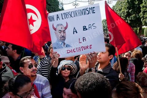 March 20, 2012: Nearly 6,000 Tunisians gathered Tuesday on Bourguiba Avenue in Tunis to celebrate Independence Day and “defend democracy” against “reactionary” forces, amid tensions fueled by the debate over identity and the role of religion.Tunisian flags were everywhere, horns blared, and the national anthem rang out: the demonstrators, who had come in response to calls on social media and from civic movements, chanted, “The people want a secular state!” “No to reactionary thinking, no to the caliphate,” or “We will not let obscurantist forces steal our revolution.”
The slogans of the revolution—“work, freedom, dignity”—were also chanted in unison. “In the name of the worker and the farmer, we continue to fight,” proclaimed one banner, while another demanded “jobs, or the government’s resignation.”  The 56th anniversary of independence—achieved on March 20, 1956, after 75 years of French protectorate rule—is taking place against a delicate backdrop, marked by growing tensions between the “Islamist” camp—which won the elections—and the “modernist” camp. The debate, exacerbated by incidents linked to Salafist radicals, centers on the question of Tunisian identity and the role religion should play in the country’s future constitution.