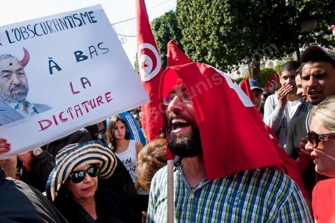 March 20, 2012: Nearly 6,000 Tunisians gathered Tuesday on Bourguiba Avenue in Tunis to celebrate Independence Day and “defend democracy” against “reactionary” forces, amid tensions fueled by the debate over identity and the role of religion.Tunisian flags were everywhere, horns blared, and the national anthem rang out: the demonstrators, who had come in response to calls on social media and from civic movements, chanted, “The people want a secular state!” “No to reactionary thinking, no to the caliphate,” or “We will not let obscurantist forces steal our revolution.”
The slogans of the revolution—“work, freedom, dignity”—were also chanted in unison. “In the name of the worker and the farmer, we continue to fight,” proclaimed one banner, while another demanded “jobs, or the government’s resignation.”  The 56th anniversary of independence—achieved on March 20, 1956, after 75 years of French protectorate rule—is taking place against a delicate backdrop, marked by growing tensions between the “Islamist” camp—which won the elections—and the “modernist” camp. The debate, exacerbated by incidents linked to Salafist radicals, centers on the question of Tunisian identity and the role religion should play in the country’s future constitution.